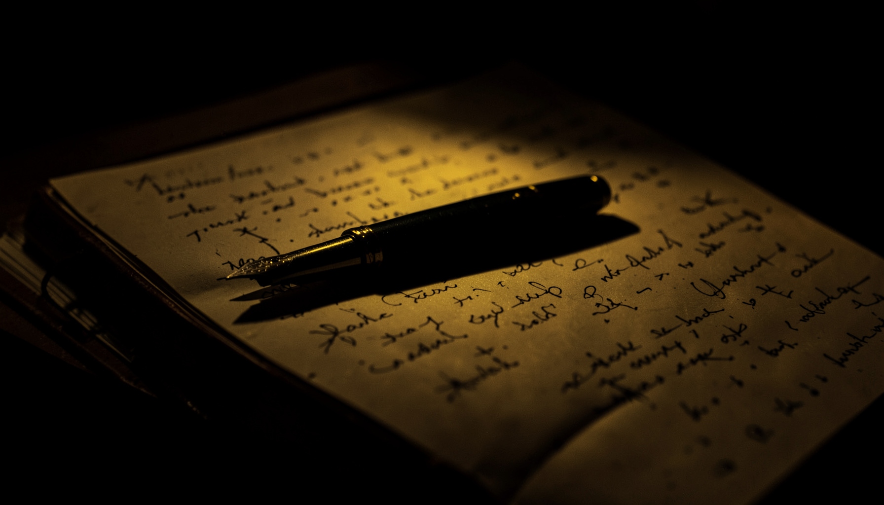 Dark, low-key photograph of a fountain pen resting across a leather-bound journal, warm sepia light falling across handwritten pages in deep shadow.
